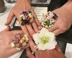 three people holding flowers in their hands at a table with menus and glasses on it