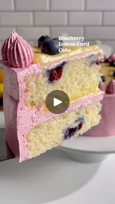 a slice of blueberry lemon card cake on a plate with the rest of the cake in the background