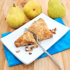 two pears and one piece of pie on a plate with a fork next to it