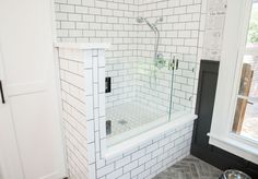 a white tiled bathroom with a walk in shower