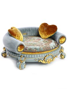 an ornate chair with two stuffed animals on it's back and seat cushion in the shape of a heart