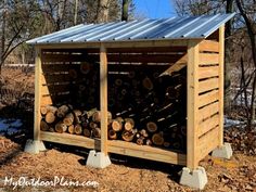 a wooden shed with logs stacked in it