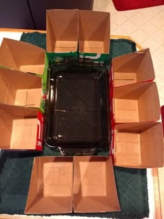 several open boxes sitting on top of a green tablecloth covered floor with red and white stripes