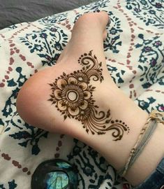 a woman laying on top of a bed covered in henna