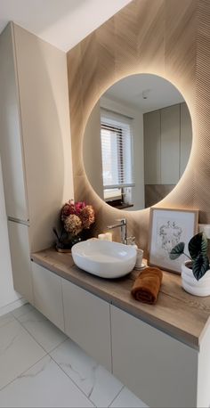 a bathroom with a sink, mirror and plants on the counter in front of it