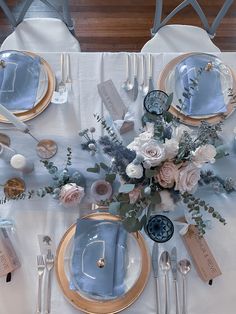 the table is set with flowers and silverware