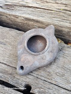 an old cast iron object sitting on top of a wooden bench