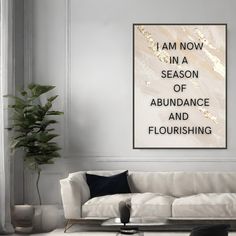 a living room filled with furniture and a large poster on the wall above it that says i am now in a season of abundance and flourishing