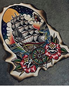 a wooden sign with a ship on it and flowers painted on the side of it