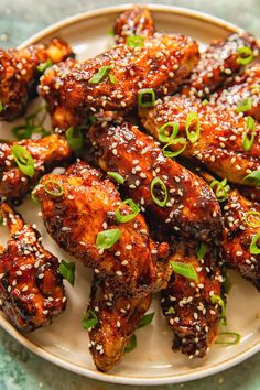 chicken wings with sesame seeds and scallions on a plate