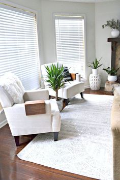 a living room with two chairs and a rug in front of the couches is shown