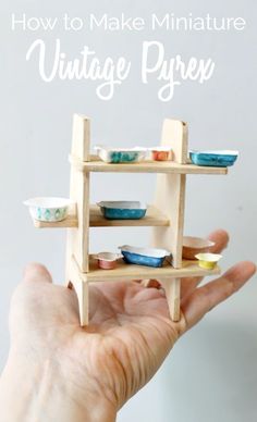 a hand holding a miniature wooden shelf with bowls on it and the words how to make miniature vintage pyron