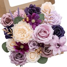 a bouquet of purple and white flowers in a cardboard box