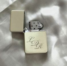 a lighter that is laying on top of a white sheet with the word pdp engraved on it