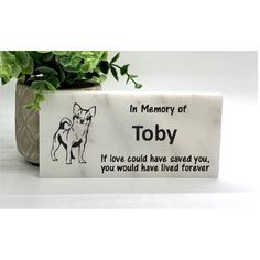 a memorial block with a dog on it and the words in memory of tobby