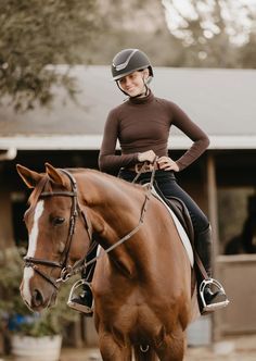 a woman riding on the back of a brown horse