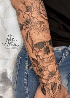 a woman's arm with a skull and flowers on it