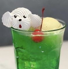 a green drink with ice cream and cherries in it