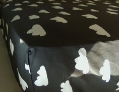 a black and white polka dot tablecloth with small white hearts on it, sitting on top of a bed