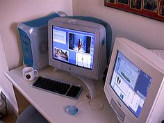 two computer monitors sitting on top of a white desk