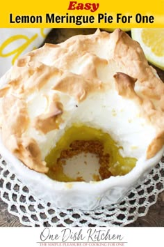 lemon meringue pie for one is in a white bowl with a slice taken out