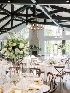 a room filled with lots of tables covered in white and gold plates