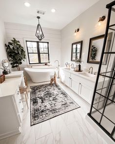 a bathroom with white walls and flooring has a rug on the floor next to the bathtub