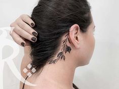 a woman with a tattoo on her neck and behind her ear is looking at the camera