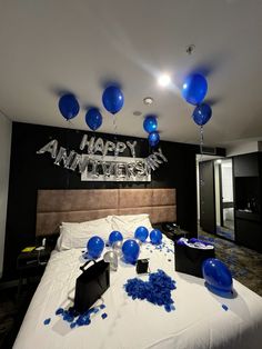 blue balloons and streamers are on the bed in this black and white themed room