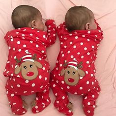 two babies are wearing red pajamas with white polka dots and reindeer faces on them, both laying down