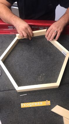 the man is working on his project with some wood pieces in front of him,