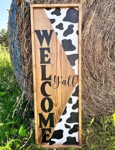 a wooden sign that says welcome to the cowgirl on it in front of some hay bales