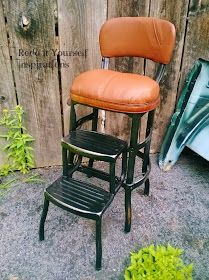 two stools sitting next to each other in front of a wooden fence