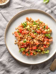 a white plate topped with rice and veggies on top of a gray table