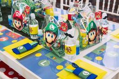 a mario birthday party table set up with water bottles and napkins