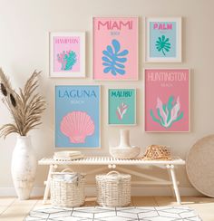 a white table topped with vases filled with flowers next to pictures on the wall