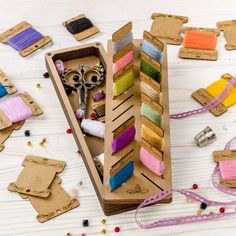 a wooden box filled with lots of different colored thread