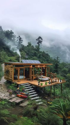 a small cabin in the middle of a forest with stairs leading up to it's roof