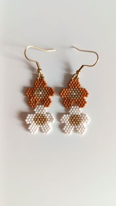 Dangling earrings with two flowers in warm autumn colours. Hand-woven earrings in dark orange and off-white. For an ultra-feminine autumn look even with the simplest outfit ;) ✓MATERIALS: -2mm Miyuki Japanese seed beads - gold stainless steel ear stud ✓COLORS: -gold, off-white, dark orange colored pearls ✓SIZE: -length: 5.8cm (with ear stud) -width: 2.2mm ✓MAINTENANCE: To prolong the life of your jewelry, be careful not to swim with it, do not leave it in a place subject to humidity and avoid co Colored Pearls, Two Flowers, Autumn Look, Earrings Fall, Autumn Colours, Fall Earrings, Ear Stud, Dark Orange, Warm Autumn