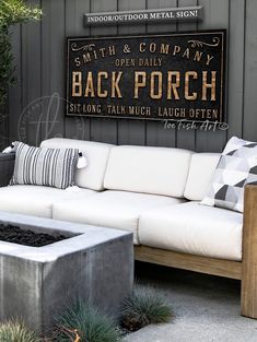 a white couch sitting on top of a cement block next to a wooden table and planter