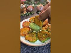 someone is dipping something into a small bowl on top of some food that is sitting on a plate