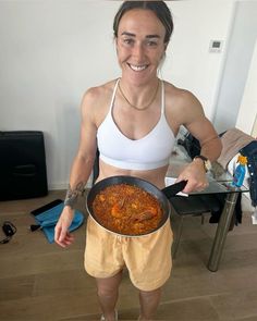 a woman holding a pan full of food