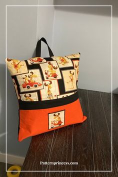 an orange and black bag sitting on top of a wooden table