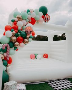 an inflatable bed with balloons and candy canes on the ground next to it