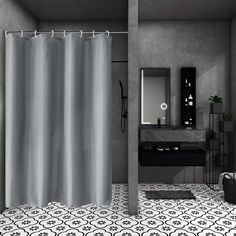 a black and white bathroom with a gray shower curtain in it's center area