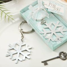 a snowflake keychain is sitting on a plate next to a bottle opener