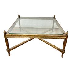 a glass and wood coffee table with gold trim