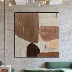 an abstract painting hangs on the wall above a green couch in a modern living room