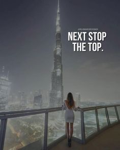 a woman standing on top of a balcony next to a tall building with the words next stop the top