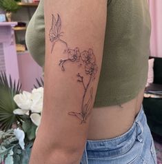 a woman's arm with a flower tattoo on the left side of her body